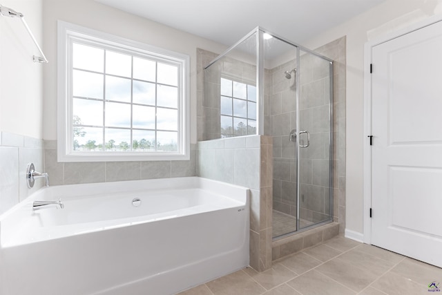 bathroom with a garden tub, a shower stall, and tile patterned flooring