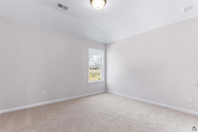 carpeted spare room with visible vents and baseboards