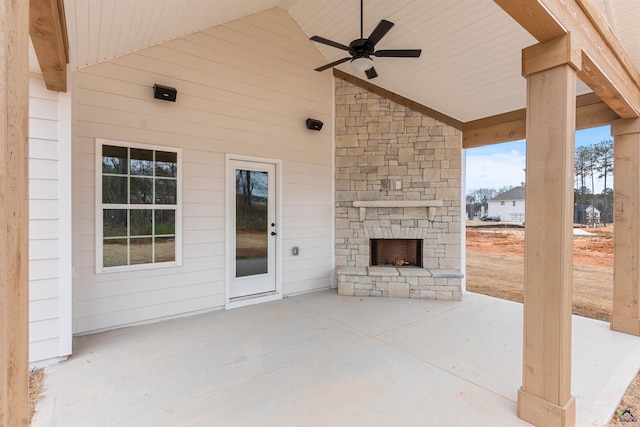 view of patio / terrace featuring ceiling fan and an outdoor stone fireplace