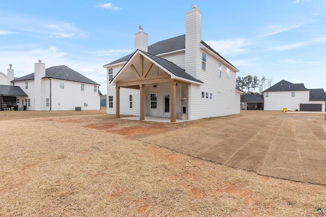 back of house with a chimney and a patio