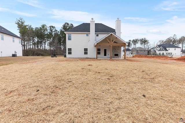 back of property featuring a yard, a chimney, and a patio area