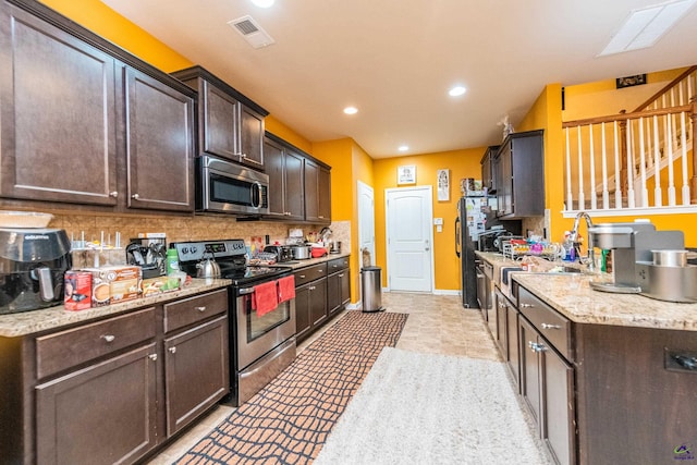 kitchen featuring sink, tasteful backsplash, appliances with stainless steel finishes, and dark brown cabinetry