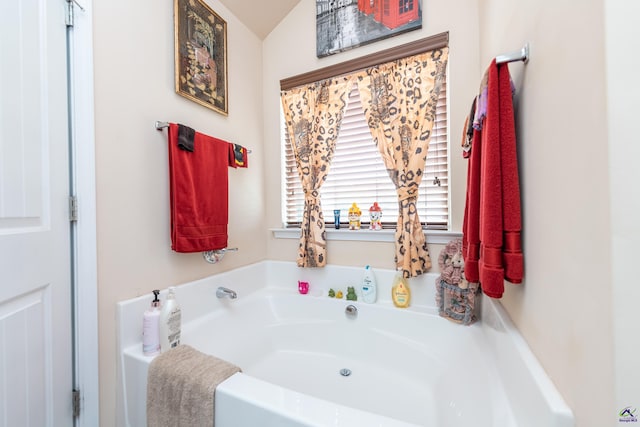 bathroom featuring lofted ceiling and a washtub