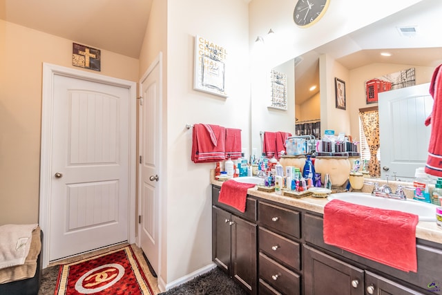 bathroom with vanity and lofted ceiling