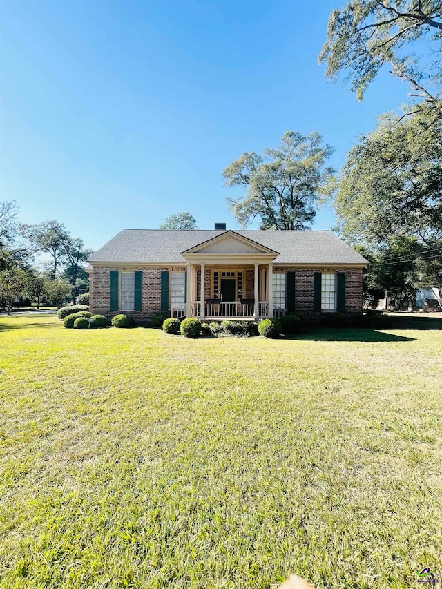 ranch-style house featuring a porch and a front yard