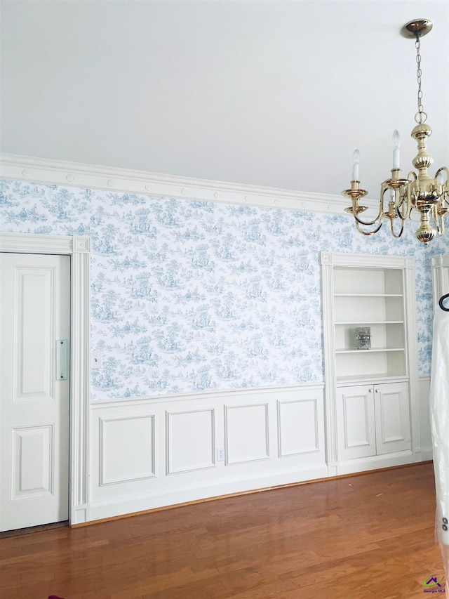 interior space featuring crown molding, hardwood / wood-style floors, and a notable chandelier