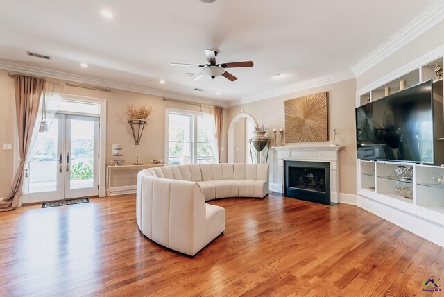 unfurnished living room with light hardwood / wood-style flooring, ornamental molding, french doors, and ceiling fan