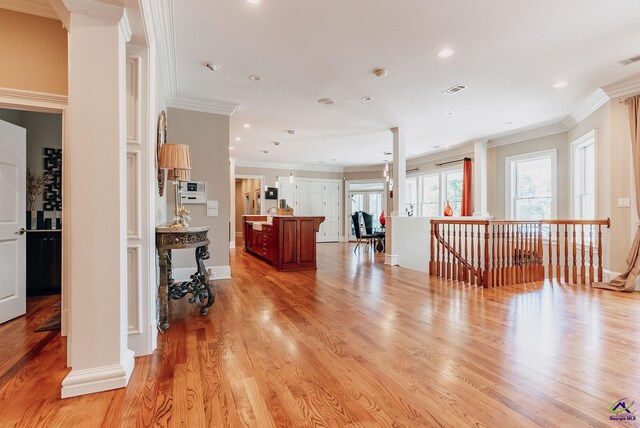 living room with ornamental molding and light wood-type flooring