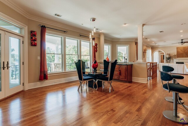 dining space with french doors, crown molding, light wood-type flooring, and ceiling fan