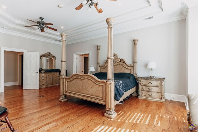 bedroom with ornamental molding, hardwood / wood-style floors, and a raised ceiling