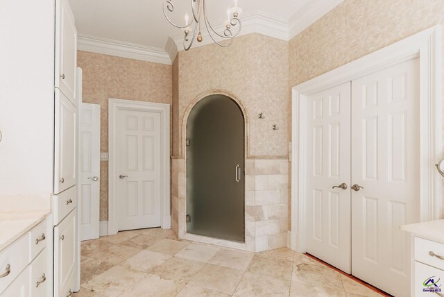 bathroom featuring vanity, crown molding, a shower with shower door, and a notable chandelier