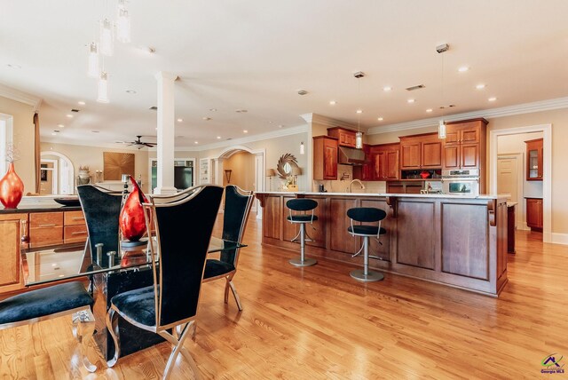 kitchen with oven, light hardwood / wood-style flooring, ceiling fan, and pendant lighting