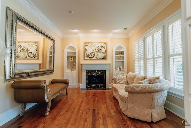 sitting room with ornamental molding, a premium fireplace, and hardwood / wood-style flooring