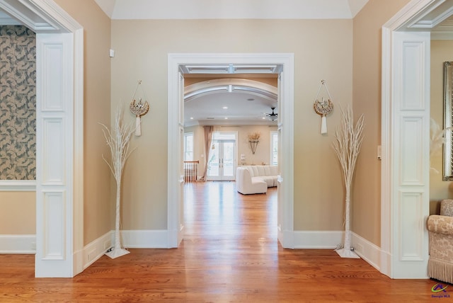 hall featuring french doors, light hardwood / wood-style flooring, and crown molding