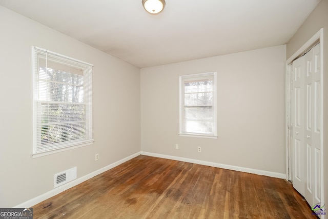 unfurnished bedroom featuring a closet and dark hardwood / wood-style flooring