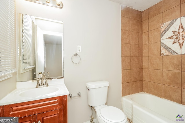 full bathroom featuring toilet, tiled shower / bath, and vanity