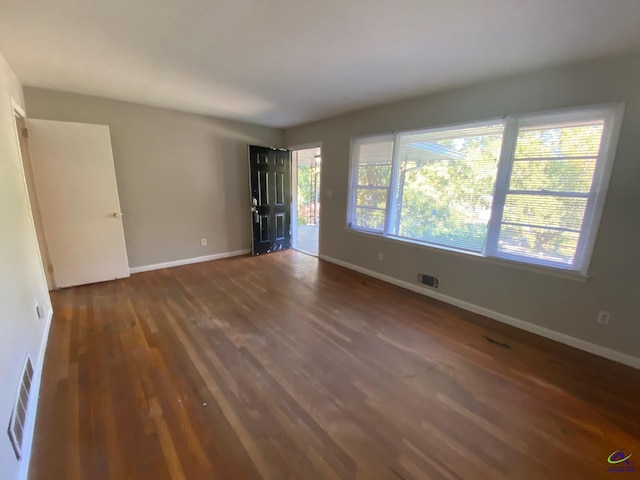 unfurnished room with dark wood-type flooring