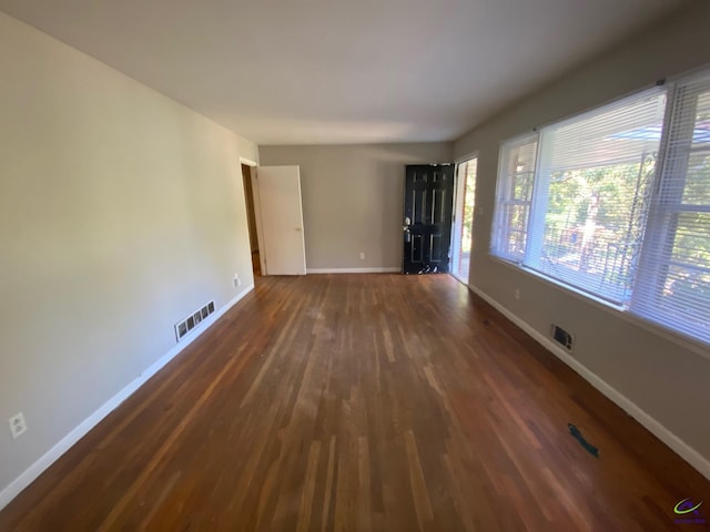 empty room with dark hardwood / wood-style flooring