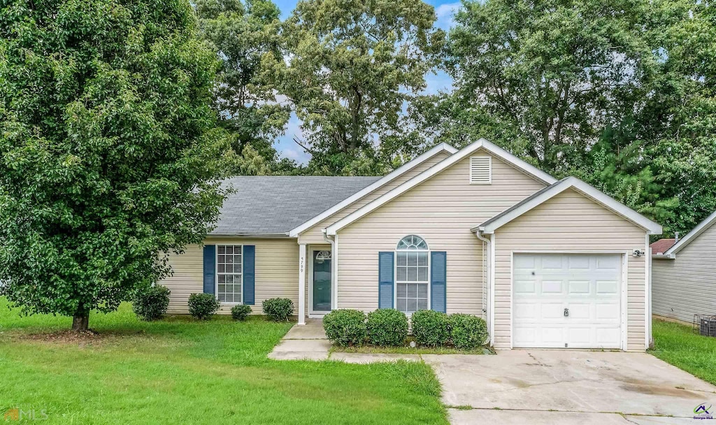 ranch-style home with a garage and a front lawn