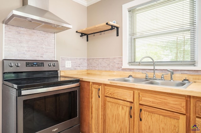 kitchen featuring stainless steel range with electric stovetop, sink, wall chimney range hood, and plenty of natural light