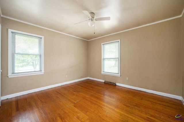 empty room featuring crown molding, wood-type flooring, and ceiling fan