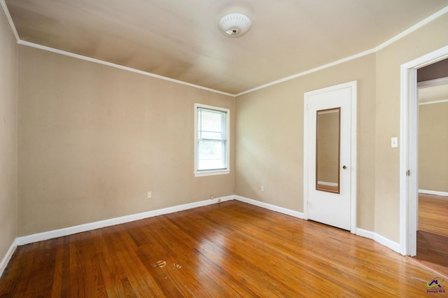 spare room with ornamental molding and hardwood / wood-style flooring