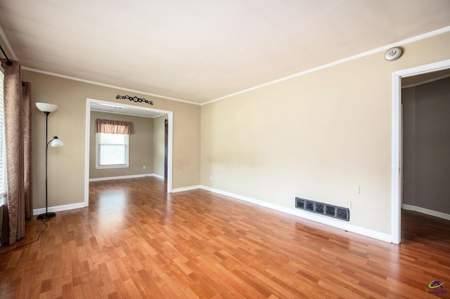 spare room with wood-type flooring and ornamental molding