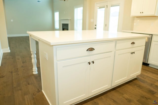 kitchen with ornamental molding, double oven, dark wood-type flooring, white cabinetry, and decorative light fixtures