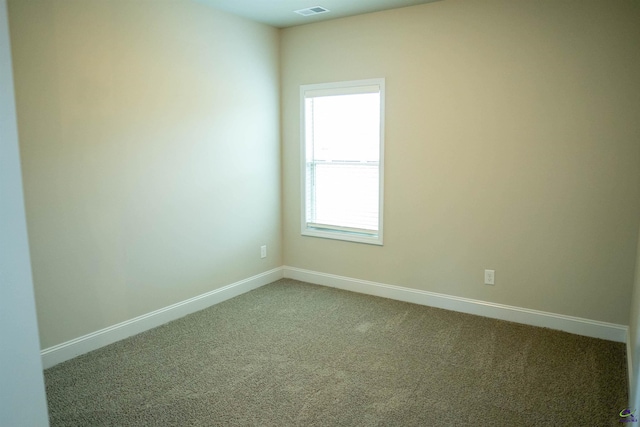 carpeted spare room featuring baseboards