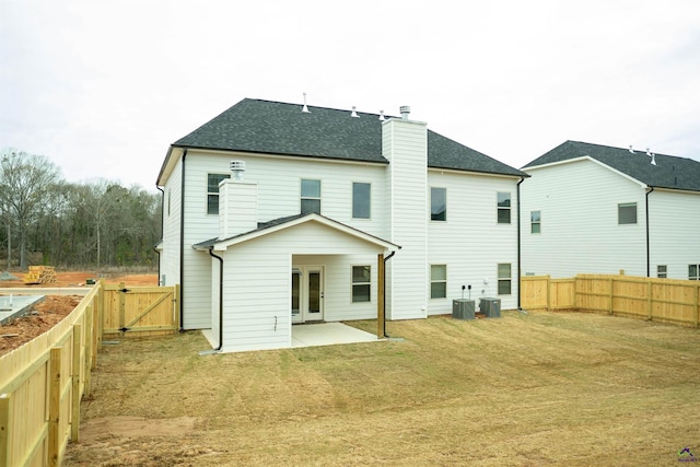 back of property with central air condition unit, a patio, a chimney, and a fenced backyard