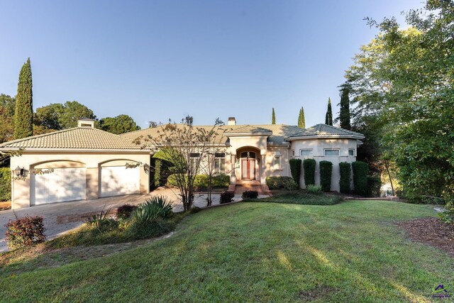 view of front of house with a front yard and a garage