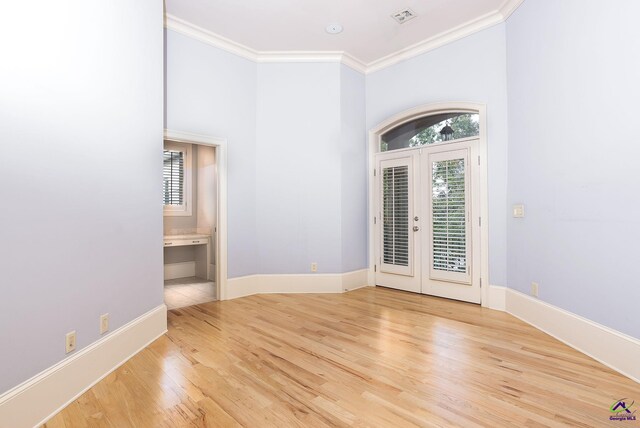 foyer entrance featuring light hardwood / wood-style flooring, french doors, and crown molding