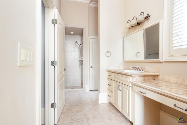 bathroom with vanity, ornamental molding, tiled shower, and tile patterned flooring