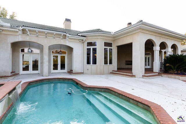 view of swimming pool featuring a patio area, french doors, and pool water feature