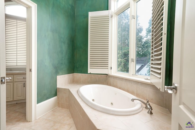 bathroom with a relaxing tiled tub and tile patterned floors