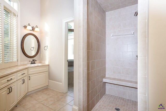 bathroom featuring vanity, tile patterned floors, a wealth of natural light, and tiled shower