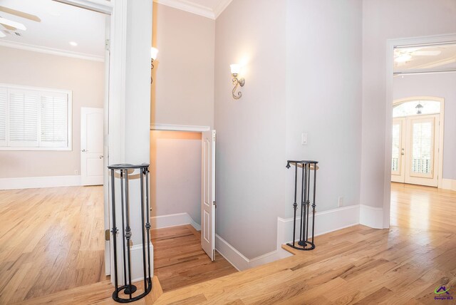 hallway with light hardwood / wood-style floors and crown molding