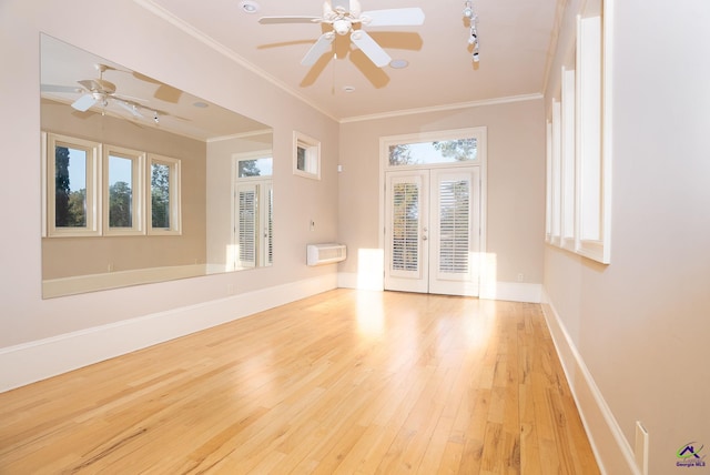 empty room featuring french doors, crown molding, light hardwood / wood-style floors, and ceiling fan