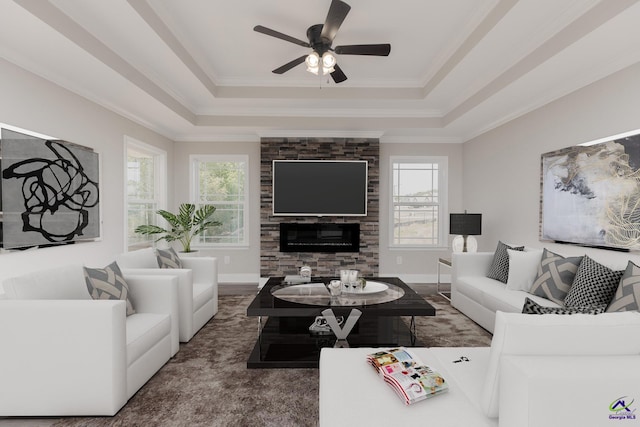 living room featuring crown molding, a stone fireplace, a raised ceiling, and plenty of natural light