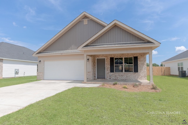 view of front of property with a front yard, a garage, covered porch, and central AC unit