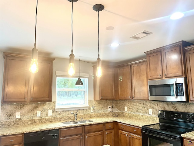 kitchen featuring a sink, decorative light fixtures, tasteful backsplash, visible vents, and black appliances