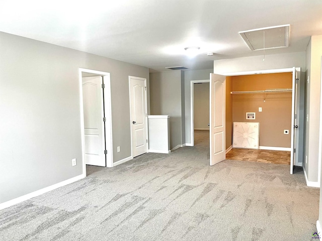 carpeted empty room with baseboards, attic access, and visible vents