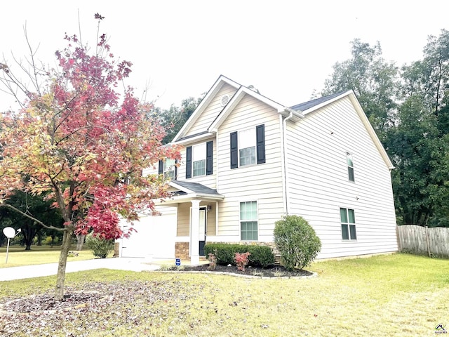traditional home with a garage, fence, driveway, and a front yard