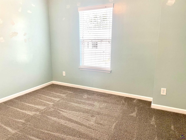 spare room featuring baseboards and carpet