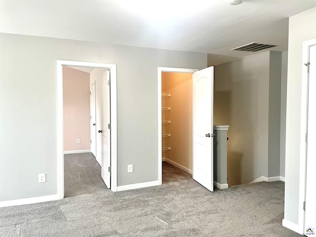 unfurnished bedroom with baseboards, visible vents, and light carpet