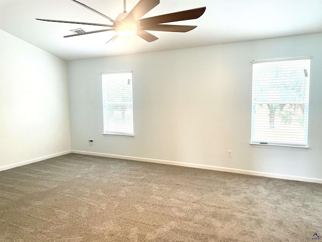 spare room with a ceiling fan, baseboards, and carpet