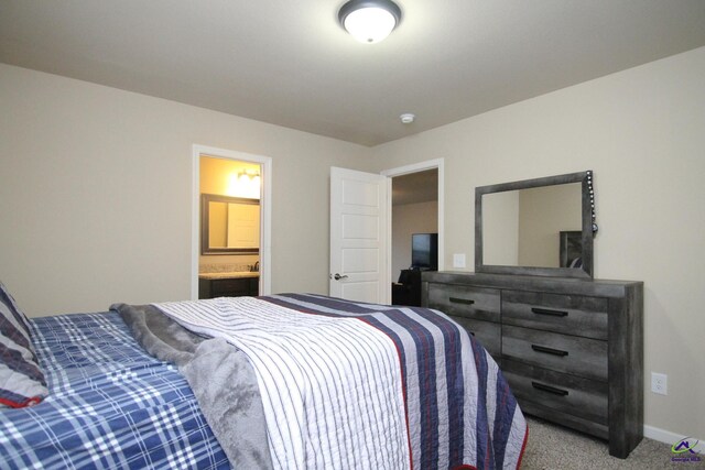 bedroom featuring ensuite bath and carpet