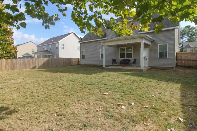 rear view of house featuring a patio and a yard