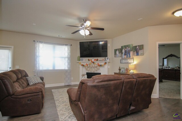 living room featuring dark wood-type flooring and ceiling fan