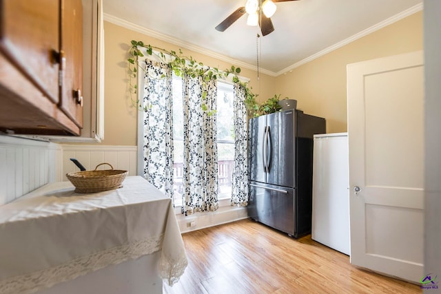 kitchen with light wood-type flooring, ornamental molding, ceiling fan, lofted ceiling, and stainless steel refrigerator